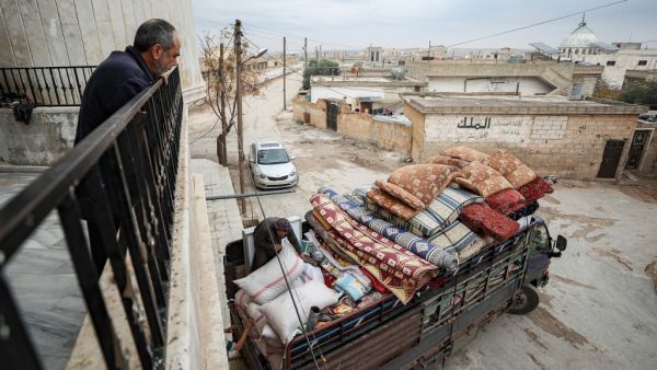 Abu Bilal, a Syrian man from the village of al-Ghadfah in Syria's northwestern Idlib province, watches from a balcony as a truck is being loaded with his belongings on December 1, 2019, before departing from the village towards Azaz in the north of Aleppo province following recent military developments in Idlib. Omar HAJ KADOUR / AFP