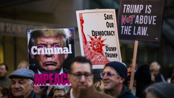 Protesters hold signs during a demonstration in part of a national impeachment rally, at the Federal Building in San Francisco, California on December 17, 2019. Protesters around the nation participated in "Nobody is Above the Law" rallies on the eve of a historic Trump impeachment vote in the United States House of Representatives. Philip Pacheco / AFP