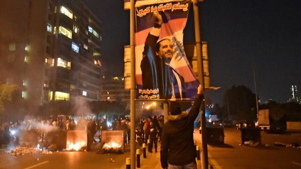 A Lebanese man fixes a poster bearing the picture of outgoing prime minister Saad Hariri as his supporters block a road in the Qasqas neighbourhood of the capital Beirut, on December 19, 2019, to denounce the nomination of Prime Minister-designate Hassan Diab. Crisis-hit Lebanon's president named today former minister Hassan Diab, backed by Shiite movement Hezbollah, as the country's new prime minister. The little-known 60-year-old engineering professor at the American University of Beirut(AUB) replaces out
