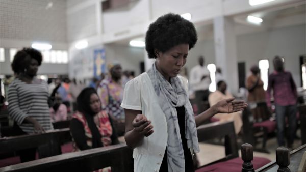 Sudanese Christian woman prays during a Sunday service (AFP)