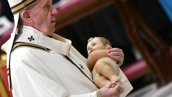 Pope Francis carries a statue of baby Jesus during a mass on Christmas eve marking the birth of Jesus Christ on December 24, 2019, in St Peter's basilica at the Vatican. Alberto PIZZOLI / AFP