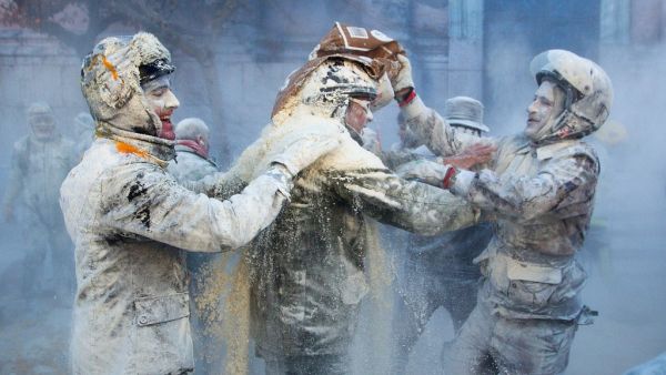 Revellers dressed in mock military garb cover themselves in flour as they take part in the "Els Enfarinats" battle in the southeastern Spanish town of Ibi on December 28, 2019. During this 200-year-old traditional festival participants known as Els Enfarinats (those covered in flour) dress in military clothes and stage a mock coup d'etat as they battle using flour, eggs and firecrackers outside the city town hall as part of the celebrations of the Day of the Innocents, a traditional day in Spain for pulling