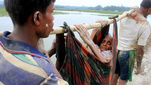 Rohingya refugees carry an elderly woman from Rakhine state in Myanmar along a path near Teknaf in Bangladesh on September 3, 2017. (AFP PHOTO / R. ASAD)