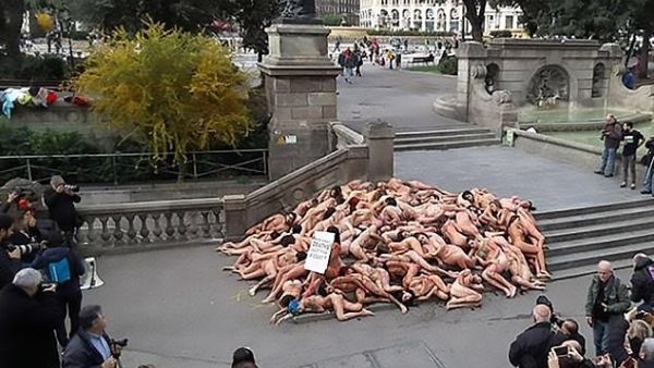 The protest consisted of dozens of activists lying on the ground while covered in fake blood as a sitting woman holding a sign shouted out 'suffering is not elegant'. (CEN/ AnimaNaturalis)
