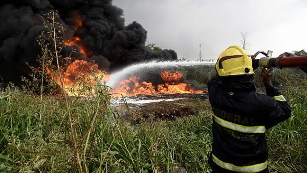Federal firefighters try to put out fire from a ruptured oil pipeline at Peace Estate, Baruwa at Ipaja district of Lagos, Nigeria's commercial capital, on Thursday. (AFP)
