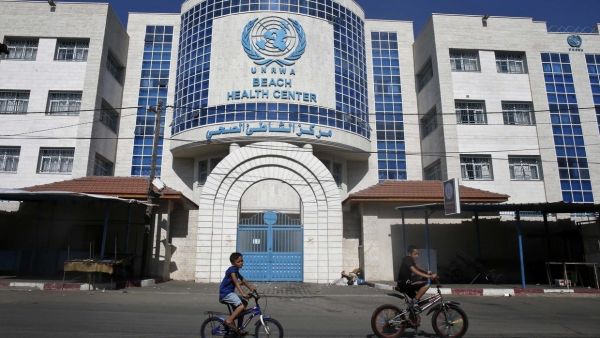 Children ride their bicycles in front of a health centre run by the United Nations Relief and Works Agency (UNRWA) in Gaza City on October 2, 2018, closed in protest against job cuts announced by the UNRWA. (AFP)