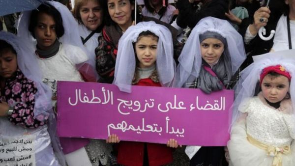 Young Lebanese girls disguised as brides hold a placard as they participate in a march against marriage before the age of 18, in the capital Beirut on March 2, 2019. (AFP/ File Photo)