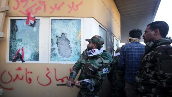 In this file photo taken on December 31, 2019, members the Hashed al-Shaabi, a mostly Shiite network of local armed groups trained and armed by powerful neighbour Iran, smash the bullet-proof glass of the US embassy's windows in Baghdad. (AFP/ File Photo)