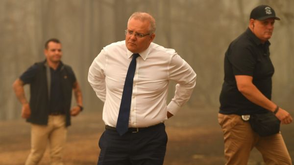 Australia's Prime Minister Scott Morrison (C) visits a resident's property in an area devastated by bushfires in Sarsfield, Victoria state on January 3, 2020. Australia ordered residents and tourists out of the path of raging bushfires on January 3 as the country braced for a weekend heatwave expected to fan the deadly inferno. James ROSS / POOL / AFP