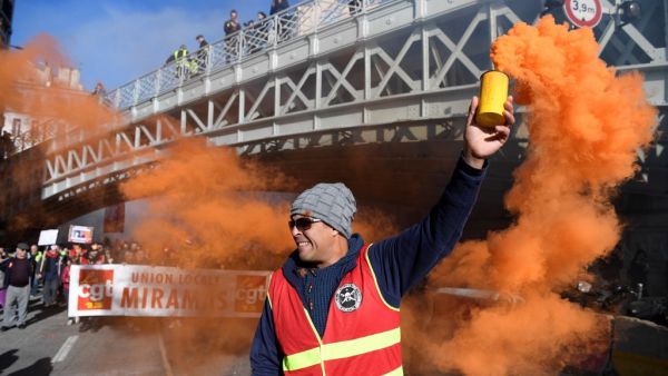 A man holds a smoke grenade as he takes part in a demonstration against the pension reform in Marseille, on January 9, 2020. (AFP/ File Photo)