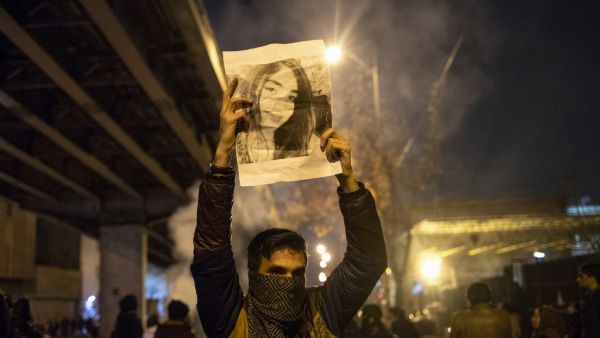 An Iranian man holds a picture of a victim of the Ukrainian Boeing 737-800 plane crash during a demonstration in front of Tehran's Amir Kabir University on January 11, 2020. Demonstrations broke out for a second night in a row after Iran admitted to having shot down a Ukrainian passenger jet by mistake on January 8, killing all 176 people on board. STR / AFP