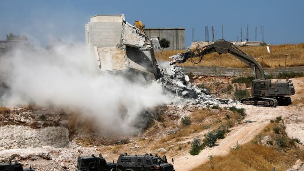 Israeli security forces tear down one of the Palestinian buildings still under construction. AHMAD GHARABLI/AFP