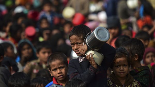 A Rohingya Muslim refugee waits with others for food aid at Thankhali refugee camp in Bangladesh's Ukhia district on January 12, 2018. (AFP Photo/Munir Uz Zaman)