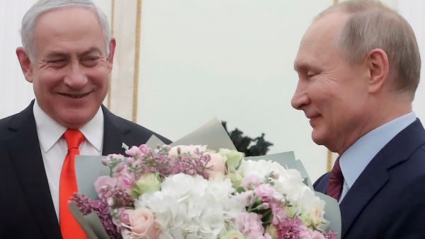 Russian President Vladimir Putin holds flowers next to Israeli Prime Minister Benjamin Netanyahu as they meet at the Kremlin in Moscow on January 30, 2020. MAXIM SHEMETOV / POOL / AFP