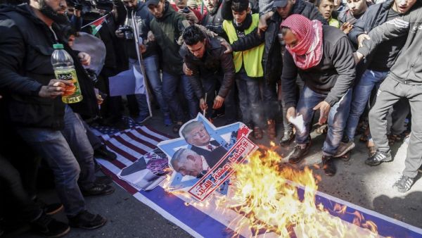 Palestinian demonstrators burn portraits of US President Donald Trump and Israeli Prime Minister Benjamin Netanyahu with the slogan in Arabic "Down with the Deal of the Century" as well as flags of their respective nations during a protest in Gaza's Jabalia refugee camp on January 31, 2020 against a proposed peace plan by the US president. AFP