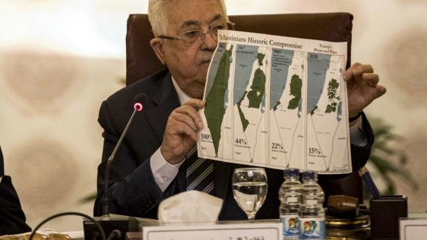 Palestinian president Mahmud Abbas holds a placard showing maps of (L to R) historical Palestine, the 1947 United Nations partition plan on Palestine, the 1948-1967 borders between the Palestinian territories and Israel, and a current map of the Palestinian territories without Israeli-annexed areas and settlements, as he attends an Arab League emergency meeting discussing the US-brokered proposal for a settlement of the Middle East conflict at the league headquarters in the Egyptian capital Cairo on Februar