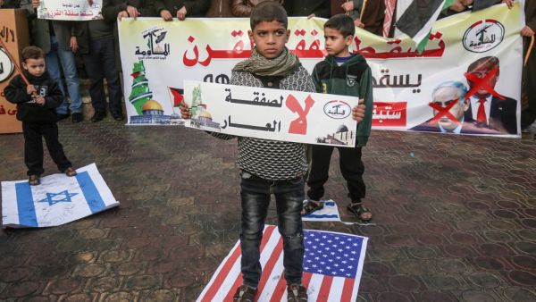 A Palestinian demonstrator takes part in a protest against a US-brokered Middle East peace plan, while holding placard that reads in Arabic "No to the deal of shame", in Rafah in the southern Gaza Strip, on February 1, 2020. SAID KHATIB / AFP