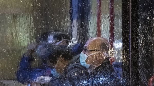 People, wearing masks, are seen through the window of a bus with on board German and foreign nationals evacuated from the Chinese city of Wuhan, the epicentre of the coronavirus outbreak, as the bus leaves Frankfurt am Main's airport to make its way to a military base in Germersheim on February 1, 2020. The passengers were to be examined for symptoms of the virus, which has killed 259 people in China so far, at a specially equipped facility at the airport before being held in quarantine for two weeks at a m