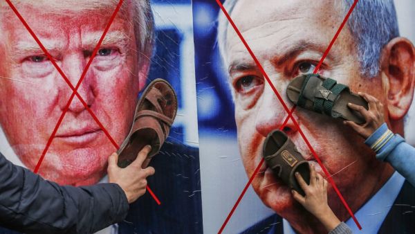 Palestinian protesters stick their footwear on posters depicting the faces of (L to R) US President Donald Trump and Israeli Prime Minister Benjamin Netanyahu during a demonstration against Trump's Middle East peace proposal in Khan Yunis in the southern Gaza Strip on February 3, 2020. SAID KHATIB / AFP