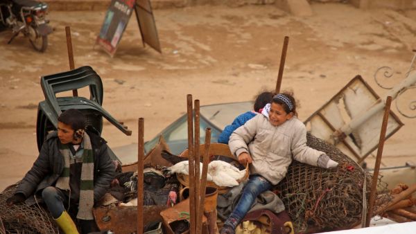 Displaced Syrian children sit in the back of a truck transporting their belongings as they pass through the town of Hazano in the northern countryside of Idlib, on February 4, 2020, fleeing northwards amid an ongoing regime offensive. A Russian-backed Syrian government offensive against the country's last rebel enclave of Idlib has displaced more than half a million people in two months, according to the United Nations. The wave of displacement, which coincides with a biting winter, is one of the largest si