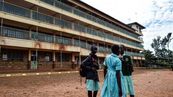 A group of pupils from Kakamega Primary School in western Kenya wait to be picked up by their parents on February 4, 2020 outside their classrooms. AFP