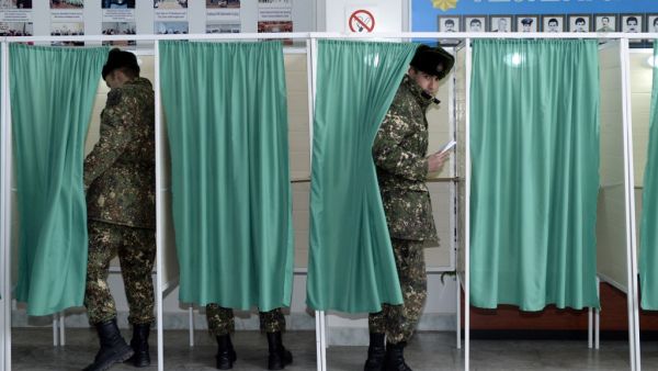 Azerbaijan's servicemen vote at a polling station during the parliamentary elections in Baku on February 9, 2020. Azerbaijan on Sunday holds snap parliamentary elections denounced by opposition parties as a feint aimed at further strengthening authoritarian President Ilham Aliyev's tight grip on power. TOFIK BABAYEV / AFP