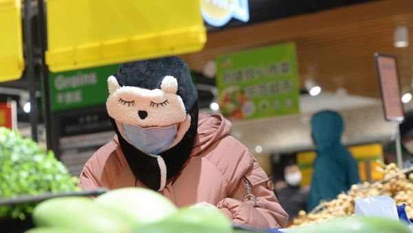 A customer wearing a protective mask shops at a supermarket in Wuhan, the epicentre of the outbreak of a novel coronavirus, in China's central Hubei province. The death toll from the novel coronavirus surged past 900 in mainland China on February 10, overtaking global fatalities in the 2002-03 SARS epidemic, even as the World Health Organization said the outbreak appeared to be stabilising. STR / AFP