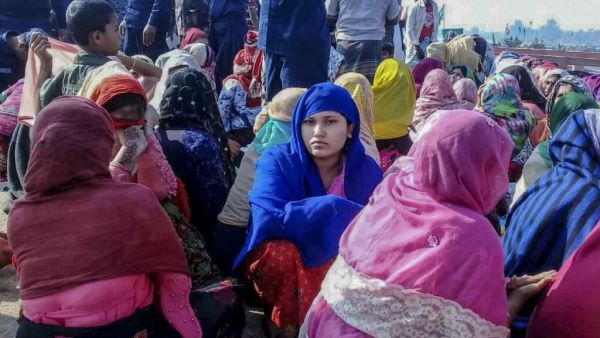 Rohingya refugees wait in an area following a boat capsizing accident, in Teknaf on February 11, 2020. At least 14 people drowned and dozens more were unaccounted for after a boat carrying Rohingya refugees sank off southern Bangladesh early February 11, officials said. STR / AFP