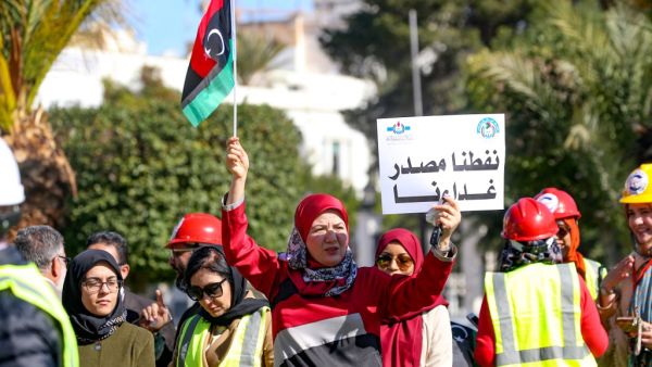 Libyans carry placards as they gather in front of the National Oil Corporation to protest against a blockade launched by groups allied to military strongman Khalifa Haftar last month of eastern Libya's main oil terminals, In the Libyan capital Tripoli on February 12, 2020. Mahmud TURKIA / AFP