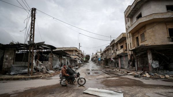 Syrians ride a motorbike in the deserted city of Kafranbel, south of Idlib city in the eponymous northwestern Syrian province, on February 15, 2020, amid an ongoing pro-regime offensive. Omar HAJ KADOUR / AFP