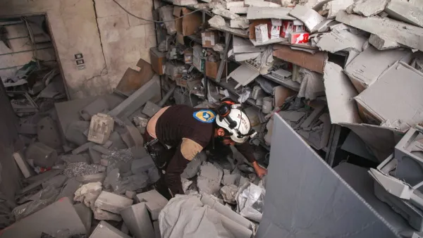 A member of the Syrian Civil Defence, also known as the "White Helmets", inspects through debris and rubble while searching for survivors at a destroyed hospital in the town of Darret Ezza, about 30 kilometres northwest of the northern Syrian city of Aleppo on February 17, 2020, after a reported air strike hit the building. AAREF WATAD / AFP