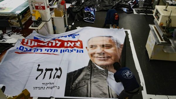 Israeli workers prepare an election banner for the Likud party showing the face of its leader Israeli Prime Minister Benjamin Netanyahu, at a printing factory in the central Israeli city of Petah Tikva, on February 20, 2020. JACK GUEZ / AFP