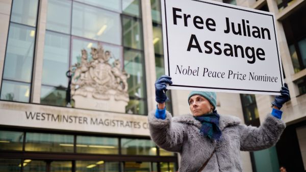 In this file photo taken on December 19, 2019, supporters of Wikileaks founder Julian Assange hold placards outside Westminster Magistrates Court in London. Tolga AKMEN / AFP