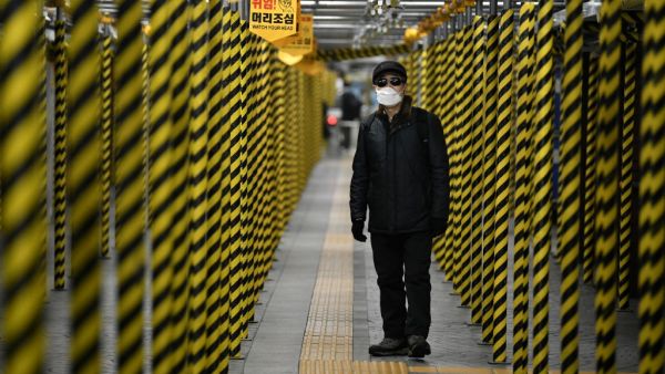 A man wearing a face mask walks between columns at a subway station being renovated in Seoul on February 22, 2020. AFP