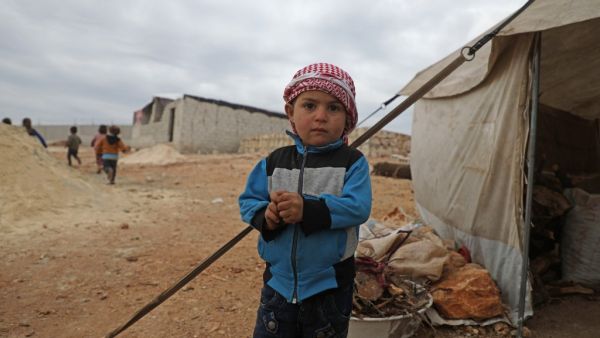  Syrian boy stands outside a tent at an informal camp in Kafr Lusin village on the border with Turkey in Syria's northwestern province of Idlib, on February 21, 2020. AFP