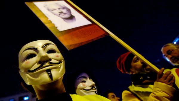 Demonstrators sporting Guy Fawkes masks take part in a protest called by Catalan National Assembly (ANC) under the motto "Journalism is not a crime" to support WikiLeaks founder Julian Assange in Barcelona on February 24, 2020. LLUIS GENE / AFP