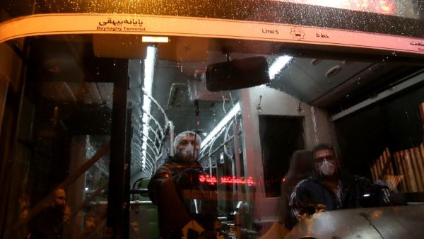 A Tehran Municipality worker cleans a bus to avoid the spread of the COVID-19 illness on February 26, 2020. Iran said Tuesday its coronavirus outbreak, the deadliest outside China, had claimed 15 lives and infected nearly 100 others -- including the country's deputy health minister. The Islamic republic's neighbours have imposed travel restrictions and strict quarantine measures after reporting their first cases in recent days, mostly in people with links to Iran. ATTA KENARE / AFP