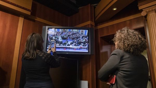 Reporters take photos of the television as they watch the Senate vote on whether or not to acquit President Donald Trump on the two articles of impeachment brought by the House of Representatives to the Senate for trial on Capitol Hill on February 5, 2020 in Washington, DC. After the House impeached Trump last year, the Senate voted today on whether to acquit or convict the President on two articles of impeachment as the trial concludes. Samuel Corum/Getty Images/AFP Samuel Corum / GETTY IMAGES NORTH AMERIC