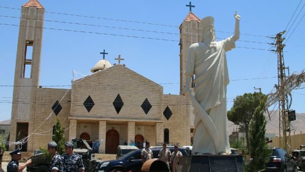 Lebanese soldiers stand guard in front of a church where a suicide bomber blew himself up the previous day in the Christian village of Al-Qaa, on June 28, 2016 (AFP Photo/)