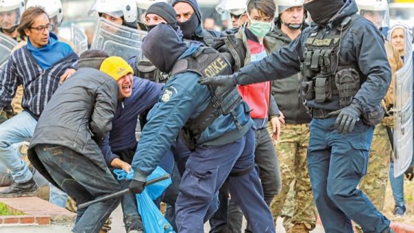 Riot police scuffle with migrants during a demonstration outside the municipal theatre of the city of Mytilene, on the island of Lesbos, on Tuesday. — AFP photo
