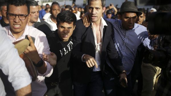 Venezuelan opposition leader and self-proclaimed acting president Juan Guaido is escorted to his car after arriving at Simon Bolivar International Airport in Maiquetia, Vargas state, Venezuela on February 11, 2020. (AFP)