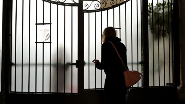 A woman asks for informations at the main entrance of the Rome's famous Visconti classics seconday school in Rome on March 5, 2020. Italy closed all schools and universities until March 15 to help combat the spread of the novel coronavirus crisis. The government decision was announced moments after health officials said the death toll from COVID-19 had jumped to 107 and the number of cases had passed 3,000. Vincenzo PINTO / AFP