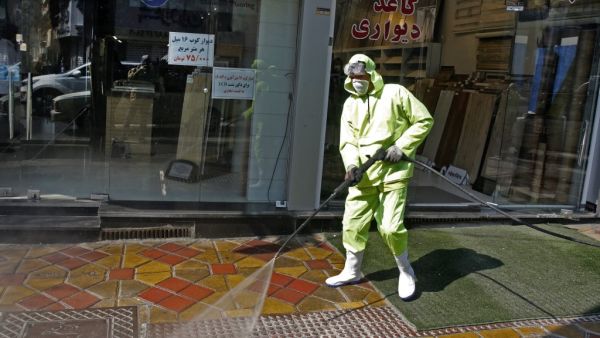 Iranian fire fighters and municipality workers disinfect a street in the capital Tehran for corona virus COVID-19 on March 5, 2020. Iran today reported 15 new deaths from the novel coronavirus and 591 fresh cases in the past 24 hours, bringing the toll to 107 dead and 3,513 infected. STR / AFP