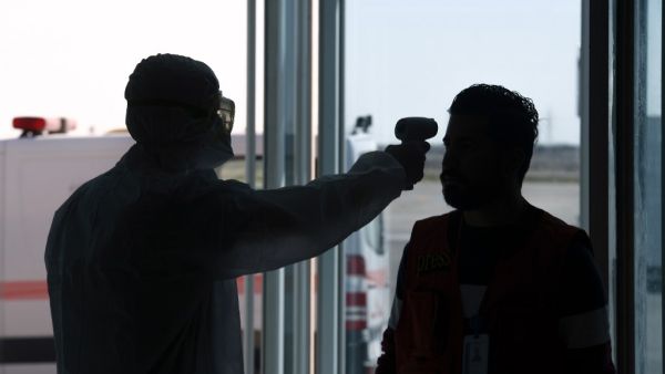 The body temperature of an Iraqi passenger returning from Iran is measured upon arrival at Najaf International Airport on March 5, 2020. Iraqi health authorities announced the country's first two deaths from the new coronavirus, one in the capital Baghdad and the other in the autonomous Kurdish region. Haidar HAMDANI / AFP