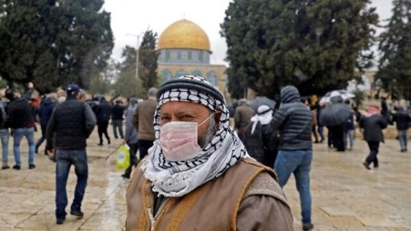 A Palestinian man wearing a protective mask as a measure of protection against the coronavirus COVID-19, stands in front of the Dome of the Rock mosque on the Temple Mount in the Old City of Jerusalem, ahead of the Friday prayers, on March 6, 2020. (Ahmad Gharabli/AFP)