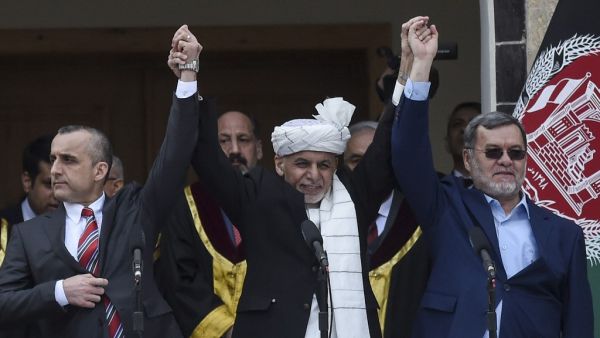 Afghan President Ashraf Ghani (C) holds hands with first vice-presidents Amrullah Saleh (L) and second vice president Sarwar Danish during his swearing-oath inauguration ceremony as the country's leader, at the Presidential Palace in Kabul on March 9, 2020. Afghanistan lurched deeper into political crisis on March 9 as the rivals for the country's leadership had themselves sworn in at simultaneous ceremonies that were interrupted by at least two blasts. WAKIL KOHSAR / AFP