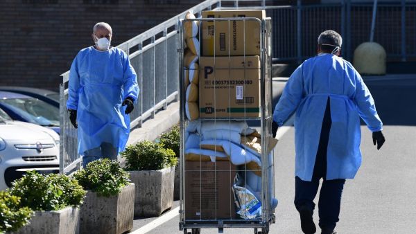 A worker pushes a cart at the hospital in Codogno, southeast of Milan, on March 11, 2020 a day after Italy imposed unprecedented national restrictions on its 60 million people Tuesday to control the deadly COVID-19 coronavirus.  Miguel MEDINA / AFP