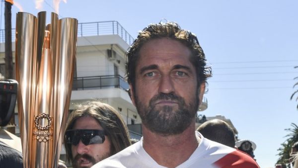 US actor Gerard Butler runs with the Olympic flame during the Olympic flame relay in Sparta on March 13, 2020 ahead of the Tokyo 2020 Olympic Games. Valerie Gache / AFP
