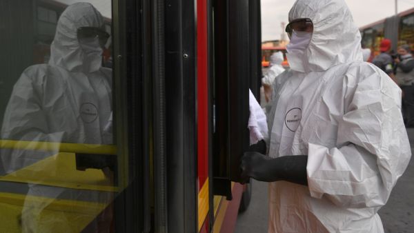 A worker washes and disinfects a bus at the bus station, as a measure to prevent the spread of the new Coronavirus, COVID-19, in Bogota, Colombia, on March 15, 2020. AFP/File