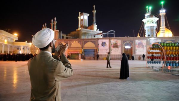 A cleric prays outside the Fatima Masumeh shrine in Iran's holy city of Qom on March 16 2020. Iran closed four key Shiite pilgrimage sites across the Islamic republic on March 16 in line with measures to stop the spread of the new coronavirus, state media reported. State television said that "upon the orders of the anti-coronavirus headquarters and the health minister, the holy shrines of" Imam Reza in Mashhad, Fatima Masumeh in Qom and Shah Abdol-Azim in Tehran were closed until further notice. MEHDI MARIZ